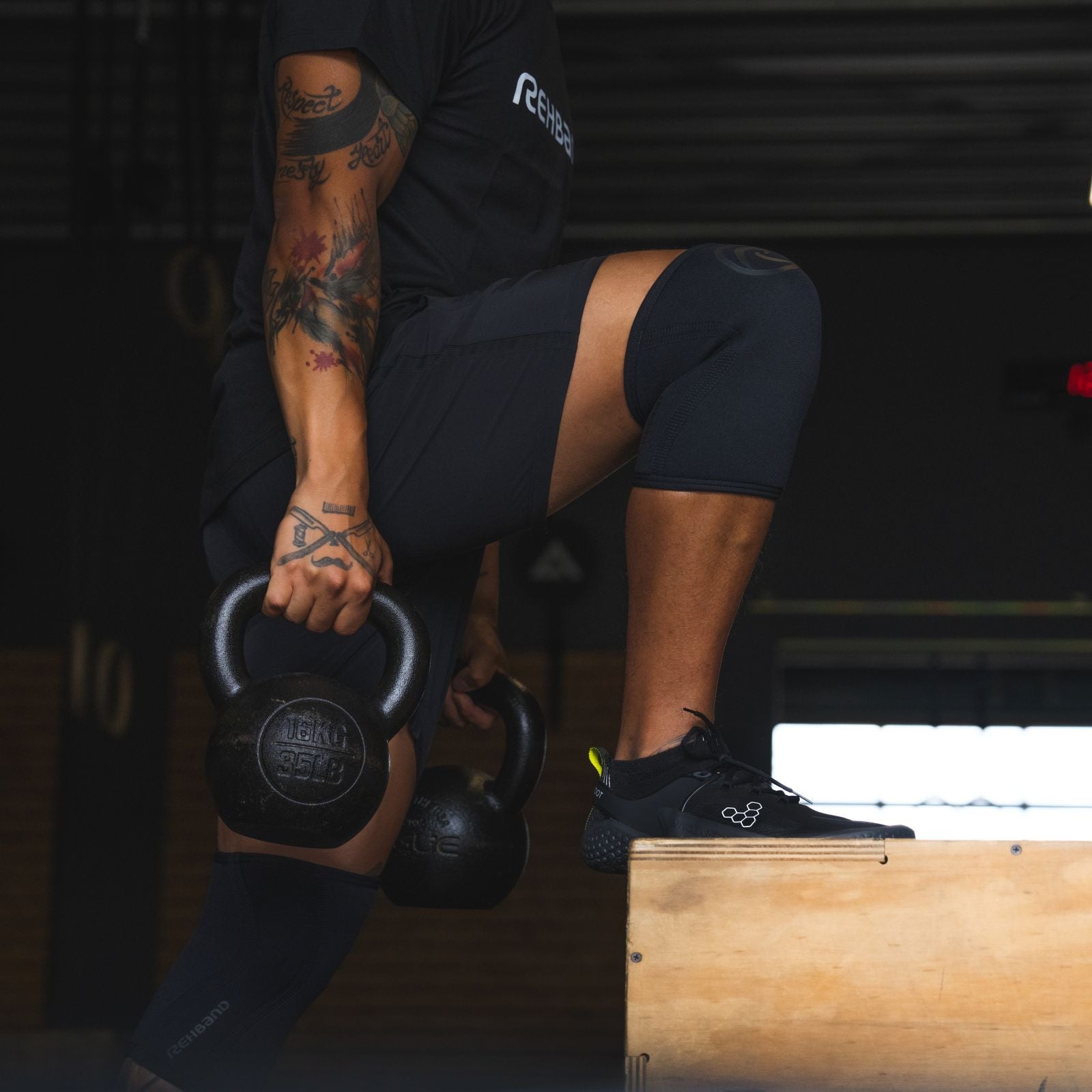 CrossFit Athlete lifting kettlebells in the gym while wearing Rehband Knee Sleeves